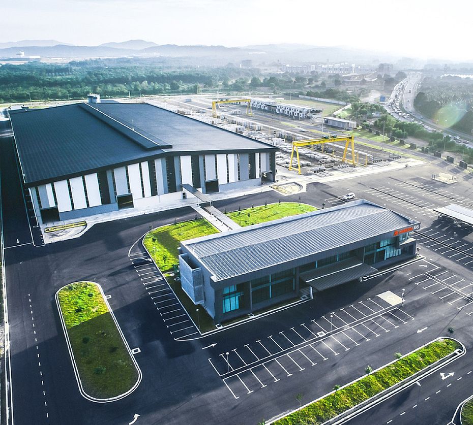 Luchtfoto fabriekslocatie met productiehal en kantoorgebouw voor heuvellandschap