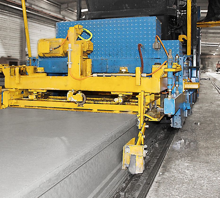 Machine de coffrage glissant sur rails laissant une dalle de béton fraîchement coulée
